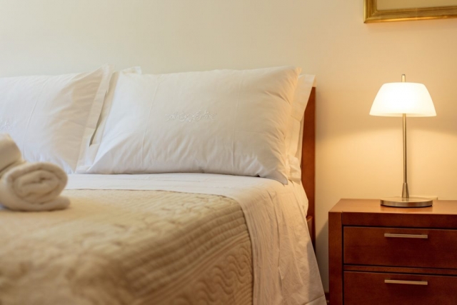 Soft pillow on a comfortable bed in the bedroom of the Villa Roglic and nightstand with the lamp