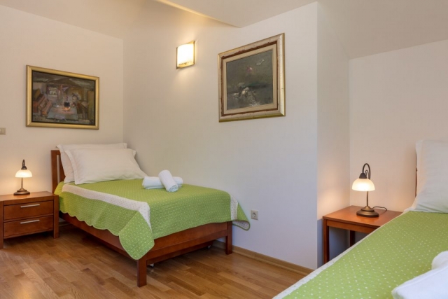 Twin bedded room in the Villa Roglic with art paintings on the wall